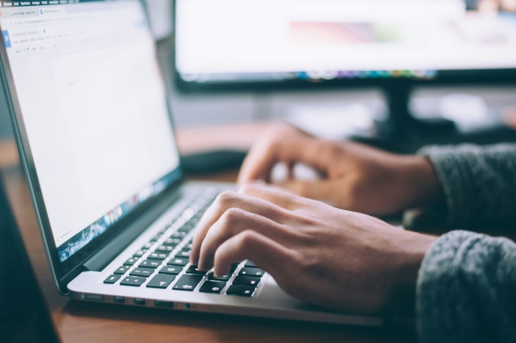 A man writing a document on a computer